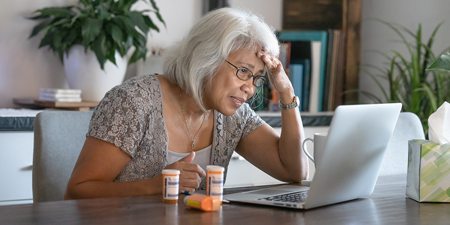 Senior Asian female confused about online help with medications